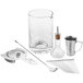 A Barfly stainless steel cocktail tool set with a clear glass, strainer, and metal tools.