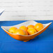 A GET Keywest sunset flare melamine bowl filled with oranges on a table.