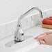 A person using a Waterloo deck mount hands-free sensor faucet with a surgical bend gooseneck spout to wash their hands.