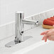 A person washing their hands using a Waterloo hands-free sensor faucet over a sink.