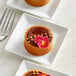 A plate of chocolate and coconut tarts with a flower on top.