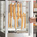 A hand removing churros from a ServIt churro rack.
