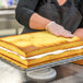 A woman holding a Rich's yellow layer cake on a tray.