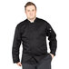 A man wearing a Uncommon Chef black long sleeve chef coat with a mesh back.