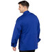 A man wearing a Uncommon Chef long sleeve blue chef jacket with a mesh back.