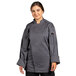 A woman wearing a Uncommon Chef grey long sleeve chef coat with mesh back.