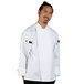 A man wearing a Uncommon Chef white long sleeve chef coat with mesh back.