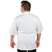 A man wearing a white Uncommon Chef Venture Pro chef coat with white mesh.