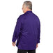 A man wearing a grape Uncommon Chef long sleeve chef coat with a mesh back.