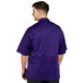 A man wearing a grape Uncommon Chef short sleeve chef coat with a mesh back.