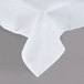A close-up of a white rectangular tablecloth with a folded edge.