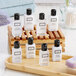 A wooden tray holding white Beekman 1802 body lotion bottles with black caps.