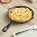 An Acopa faux cast iron skillet with macaroni and cheese on a table.