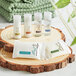 A group of EcoLOGICAL .75 oz. body lotion bottles on a wood slice.