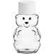A clear plastic bear with a white cap containing honey.
