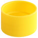 A close up of a yellow plastic 24/410 ribbed bottle cap with a small hole.