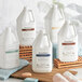 A group of Tommy Bahama 1 gallon white plastic jugs with labels on a wooden surface.