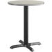 A round table with a black base and a reversible grey/white top.