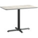 A Lancaster Table & Seating rectangular table with a white surface and black base.