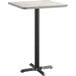 A square table with a white and gray reversible surface on a metal base with a black pole.