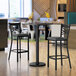 A Lancaster Table & Seating gray and white laminated bar height table with a black base and chairs