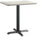 A Lancaster Table & Seating standard height table with a reversible gray and white laminated top on a metal base.