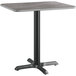 A Lancaster Table & Seating square table with a gray laminated top and a black metal base.