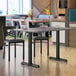 A Lancaster Table & Seating standard height table with a gray and white top and base.