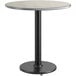 A round table with a white and grey reversible top and a black base.