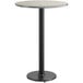 A round bar height table with a black base and a reversible grey and white laminated top.