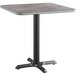 A Lancaster Table & Seating square table with a gray and white laminated top on a metal base.
