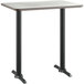 A Lancaster Table & Seating bar height table with a white birch top on a black base.