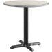 A round table with a white and grey reversible top on a black base.