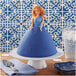 A blue cake with a Wilton doll cake topper with a blonde doll in a blue dress.