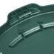 A close-up of a green Rubbermaid BRUTE trash can lid.