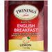 A red and white box of Twinings English Breakfast tea bags with text and a lemon.
