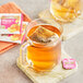 A glass mug of Twinings Glow+ Peach & Aloe Vera White Tea with a tea bag in it.