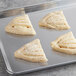 A baking sheet with four ready-to-bake Schulstad Lemon Creme Fan Danish pastries.