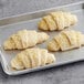 Unbaked Schulstad almond filled croissants on a baking sheet.