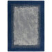 A rectangular marine blue rug with a gray border and blue and white geometric shapes.