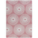 A white and pink rectangular area rug with circular designs in pink and white.