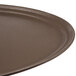 A close up of a brown Carlisle Griptite oval non skid fiberglass serving tray.