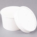 A close-up of a Huhtamaki white double poly-paper food container with a vented paper lid.