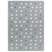 A grey and white rectangular area rug with white dots in a room.