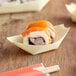 A sushi roll in an EcoChoice wooden paper boat.