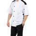 A man wearing a white Uncommon Chef short sleeve chef coat with a vented mesh back.