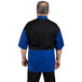A man wearing a royal blue and black Uncommon Chef Rogue Pro Vent chef coat.
