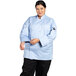 A woman wearing a Uncommon Chef long sleeve chef coat with mesh back.