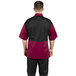 A man wearing a burgundy and black Uncommon Chef Rogue Pro Vent chef coat with mesh back.