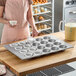 A large 20-cup glazed aluminized steel muffin pan designed for baking jumbo muffins or pecan rolls.